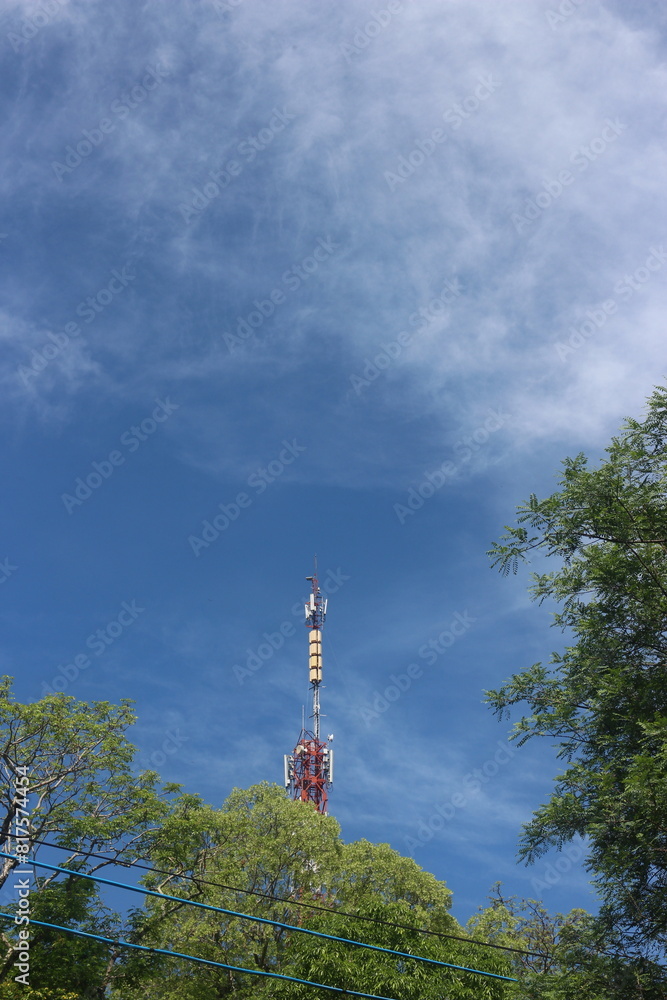 Fototapeta premium Signal tower on blue sky background. Telecommunication tower