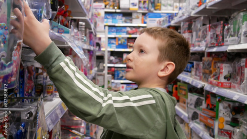 Close-up of a cute boy taking a toy from the stand of a toy shop