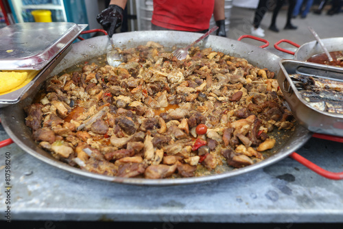 Romanian traditional meat stew being cooked in a huge pan at an outdoor food festival. photo