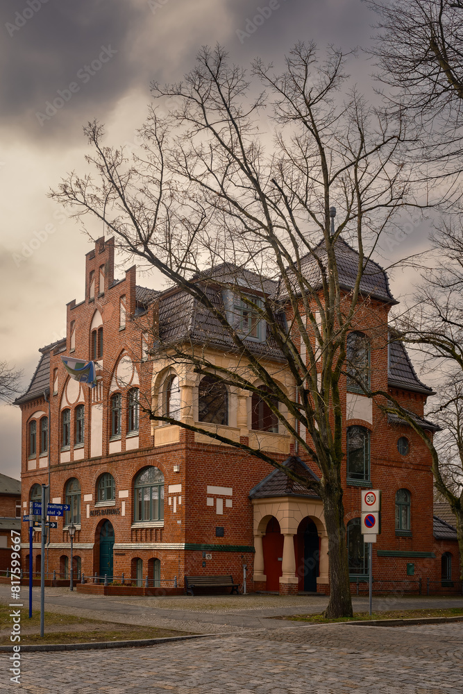 Obraz premium Dramatischer Wolkenhimmel über dem denkmalgeschützten Alten Rathaus in Hennigsdorf bei Berlin im Winter, Ansicht von Nordosten - Inschriften wurden teilweise entfernt