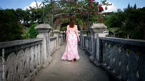 Female tourist in summer dress explores Ujung Water Palace, rear slomo shot photo