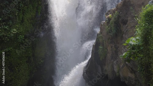 majestic Tegenungan Waterfall on the island of Bali, Indonesia. Tilt-up slow motion shot. photo