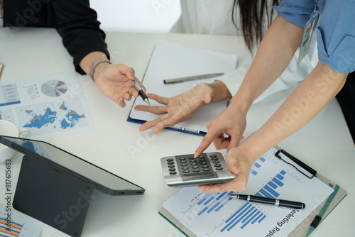 Group of Asian business people planning a project, discussing work documents.