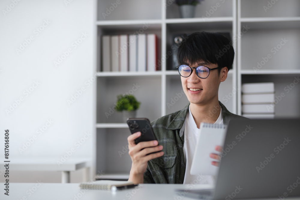 Young Asian student boy in private clothes studying online with laptop at home. Young Asian student boy in private clothes studying online with laptop at home.