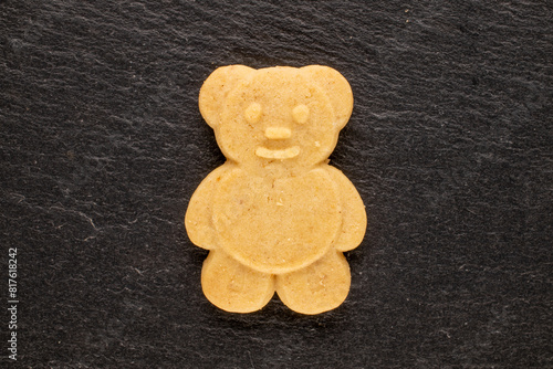 Delicious cookies in the shape of a bear on a slate stone, top view, macro.