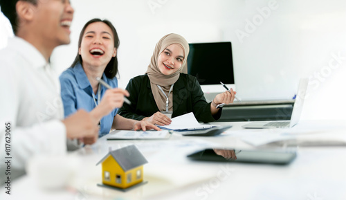 Muslim businesswoman realtor with young happy couple closing a deal and signing a contract