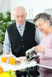 elderly woman pouring coffee for herself and husband for breakfast