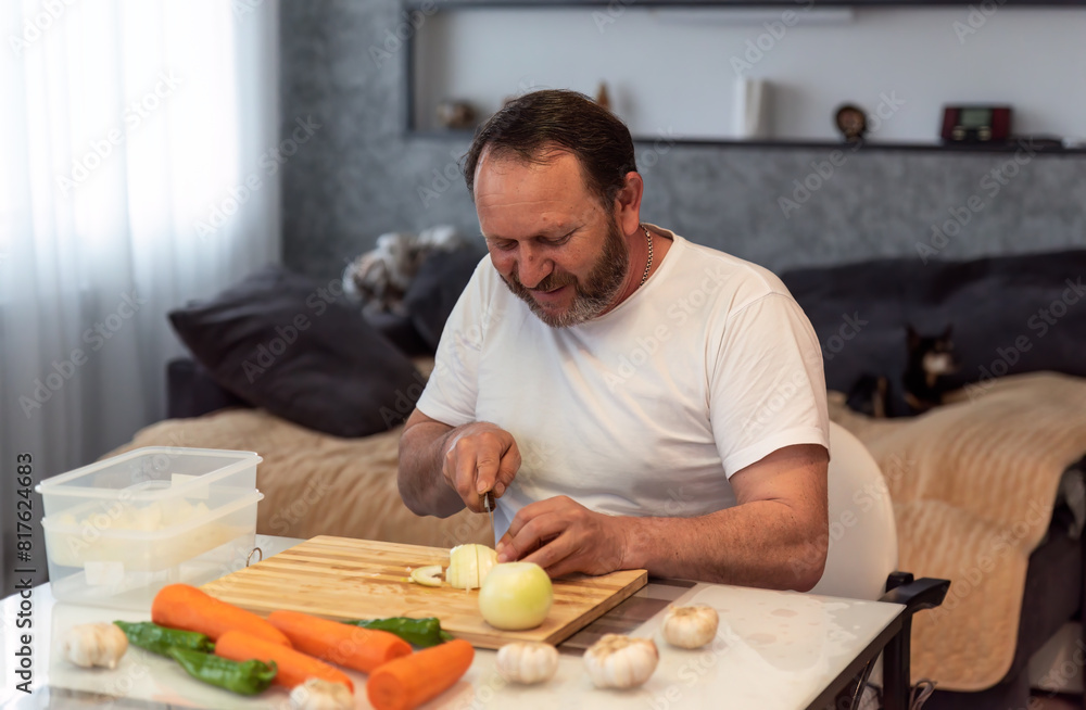 Mature man cooking pilaf, cutting vegetables in the kitchen at home Mature man cooking pilaf, cutting vegetables in the kitchen at home