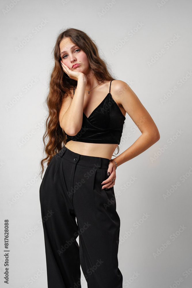 Fototapeta premium Young Woman Expressing Boredom With Hand on Face Against Neutral Background