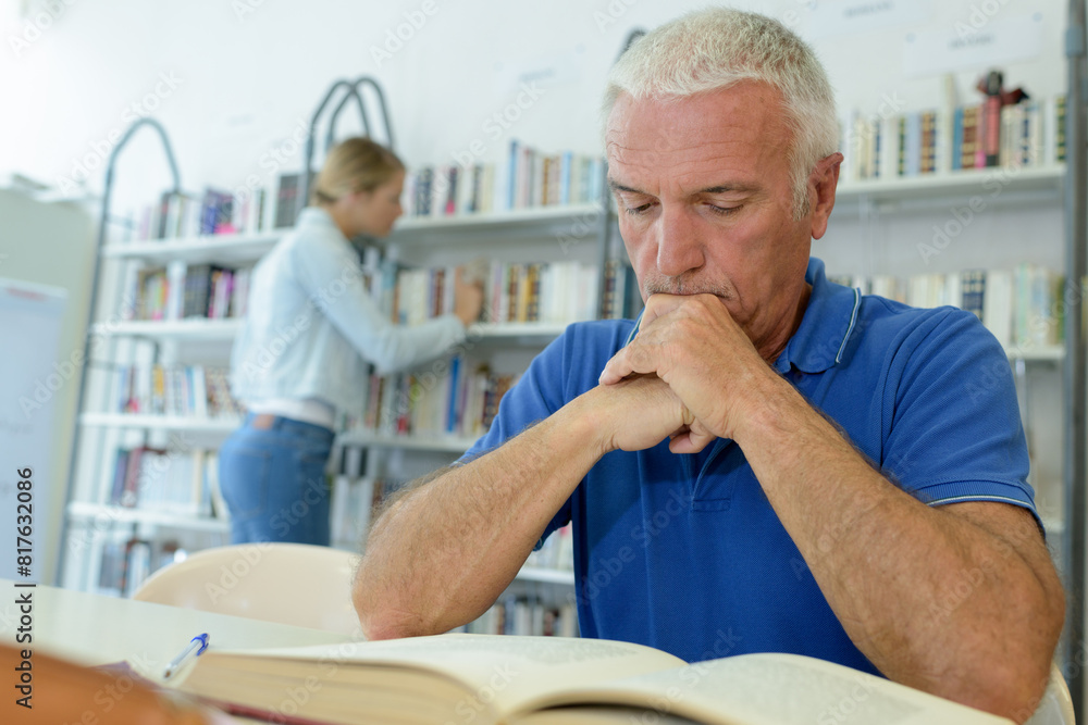 Fototapeta premium senior man with books in bookstore