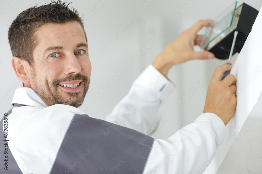 portrait of tradesman installing safety light portrait of tradesman installing safety light