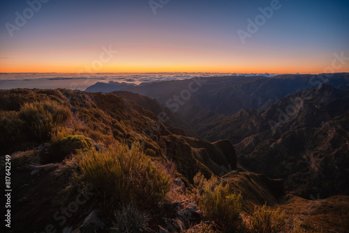 Hiking on the highest peak of Madeira Pico Ruivo next to the cottage Abrigo do Pico Ruivo. Views of the surrounding mountains lanscape during sunrise