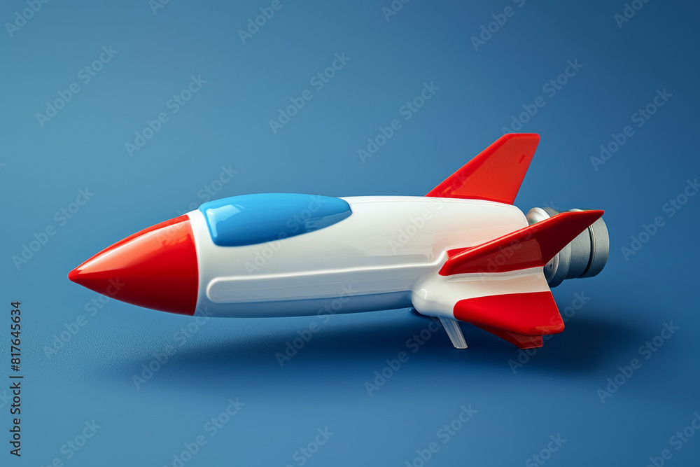 A red, white, and blue themed spaceship toy on a gradient from deep blue to white A red, white, and blue themed spaceship toy on a gradient from deep blue to white