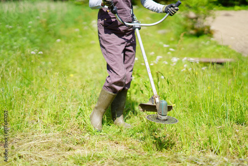 Photos 電動草刈り機で草刈りをする女性