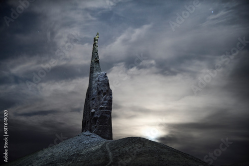 A lone spire illuminated at night during a bright moonrise. photo