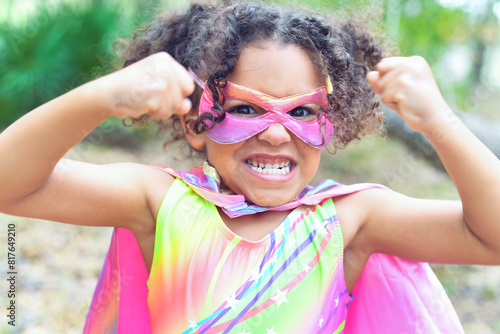 Excited child in colorful superhero costume showing strength ou photo