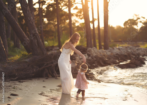 Mom and Girl Dancing in Golden hour by Water photo