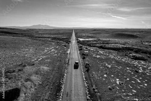 A truck drives along a long straight desolate road in Utah photo