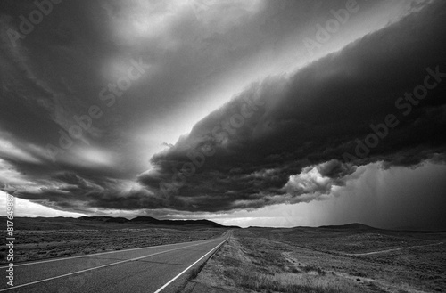 Lonely stretch of road across plains of Montana with thunderstorm photo