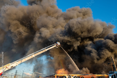 A rainbow forms in the spray as a firefighter douse a large indu photo