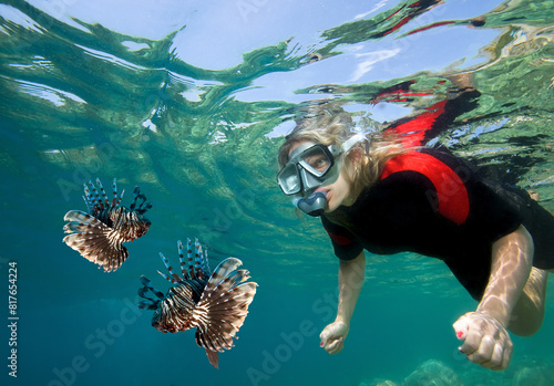 Young woman snorkeling with lionfish.