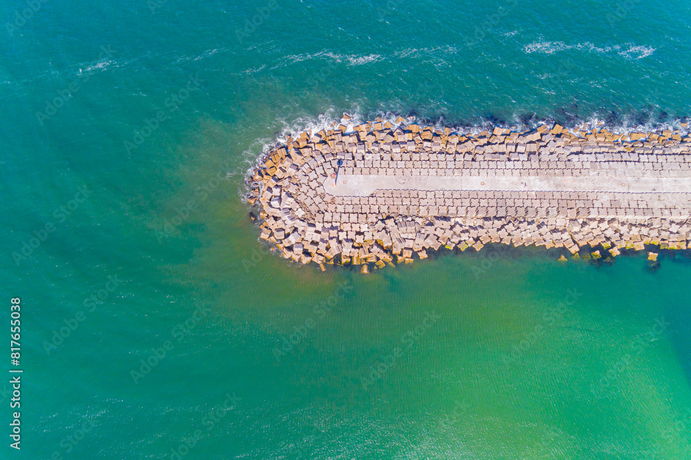 Obraz premium Aerial top view of a groyne on a beach, breakwater for harbor protection