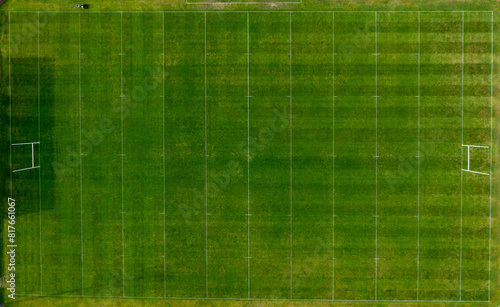 Obraz na płótnie Straight down aerial drone photo of a man cutting the grass of a British rugby pitch in the summer time showing the mower going down the sports field w salonie