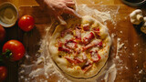 Hand Preparing Pizza with Fresh Tomatoes and Ham