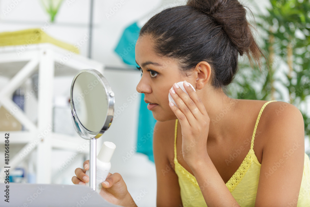 beautiful woman removing makeup in front of mirror beautiful woman removing makeup in front of mirror