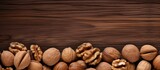 A close up copy space image of walnuts scattered on a wooden background