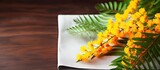 Closeup of a mimosa branch and a napkin on a table creating a visually pleasing composition with plenty of copy space in the image