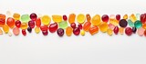 A flat lay copy space image depicting a variety of colorful candies jelly and marmalade placed on a white background