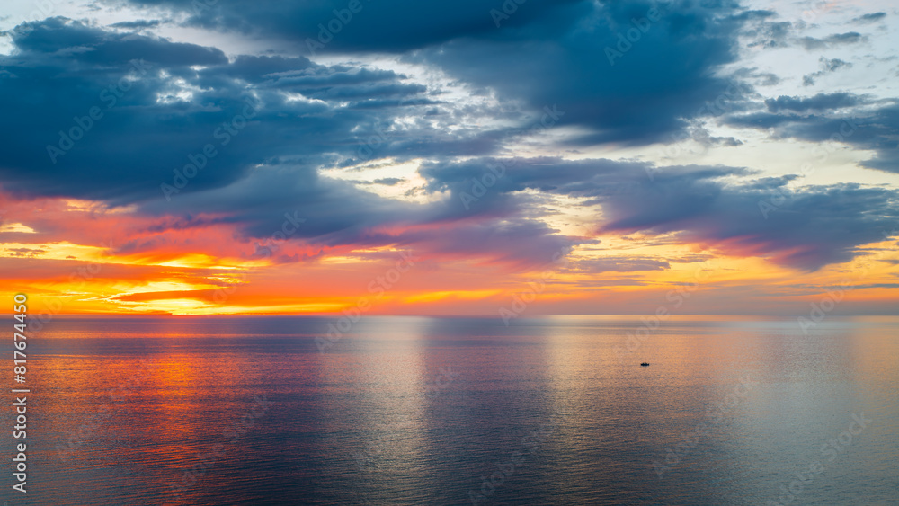 Dramatic sunset above the ocean with a boat viewed from Hallett Cove Beach, South Australia Dramatic sunset above the ocean with a boat viewed from Hallett Cove Beach, South Australia