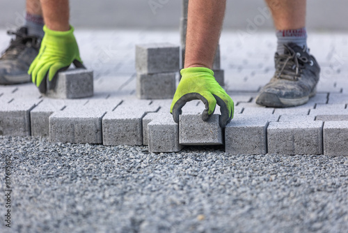 Worker doing new interlocking paving sidewalk made from concrete blocks