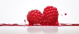 A close up photo of a raspberry dripping on a white background with ample copy space