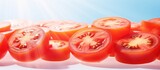 Copy space image showcasing thin slices of red ripe tomato on a bright and airy backdrop