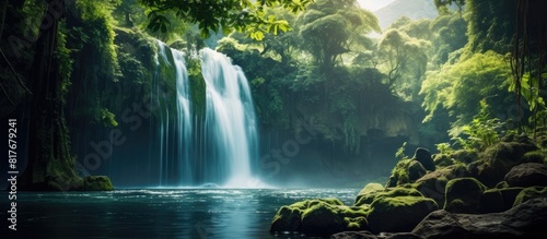 A stunning waterfall surrounded by lush greenery creating a serene and picturesque scene with ample copy space for an image