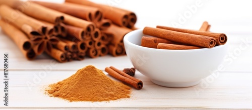 Cinnamon sticks powder and essential oil arranged on a white wooden background creating a vibrant copy space image