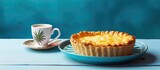 A pineapple pie sits in a ceramic dish on a light blue wooden surface accompanied by a cup of coffee The image provides ample copy space