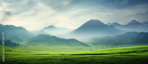 Copy space image of a picturesque green field with a majestic mountain as a backdrop amidst cloudy and rainy weather photo