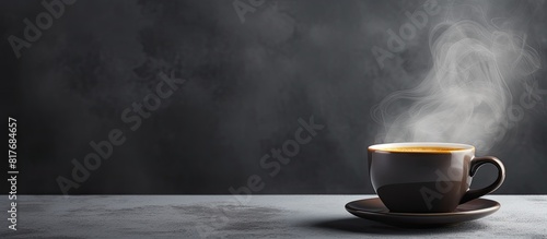 A copy space image of a steaming cup of hot coffee against a gray background photo