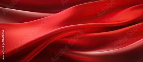 A close up shot of a red silk fabric with a satiny texture is captured in this abstract design for a background image. Creative banner. Copyspace image