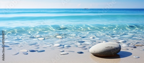 A pebble resting in the clear water on the sandy beach creating a serene and natural background for any desired content Copy space image