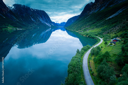 Norwegian Fjord: Scenic Road Amidst Full Reflections on an Atmospheric Summer Day photo