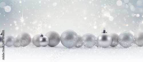 A glittery background with silver Christmas balls providing white copy space for text