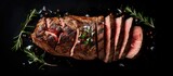 A rare grilled flank steak sliced and presented on a black background showcasing the marbled beef Top view with copy space image