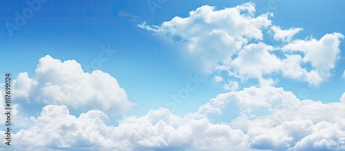 Copy space image featuring a serene blue sky adorned with fluffy white clouds