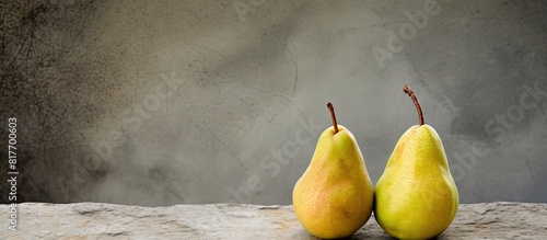 On the right side there is a group of two complete pears and a half of a pear lying on a cement surface creating a copy space image photo