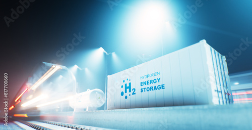A long-exposure nighttime image showing a hydrogen electrical energy storage system through an electrolysis unit in an industrial railway environment, showing a speeding train in motion.
