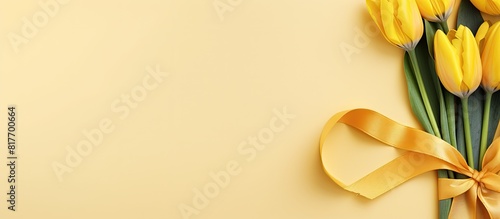 A stunning copy space image featuring five vibrant yellow tulips against a backdrop of matching yellow with a captivating ribbon heart